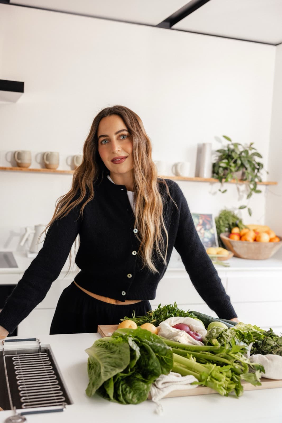 Meghan Swidler standing behind a counter of fresh greens and produce